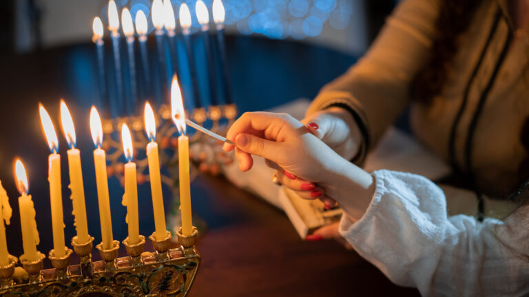 Story of Hanukkah, an adult helping a child light the candles