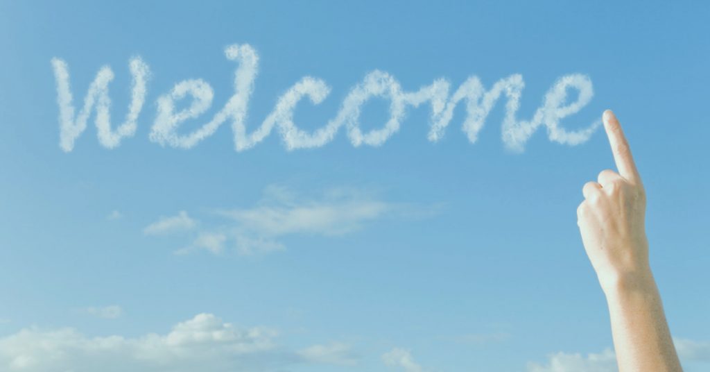 Welcome written by skywriting and finger pointing to it.