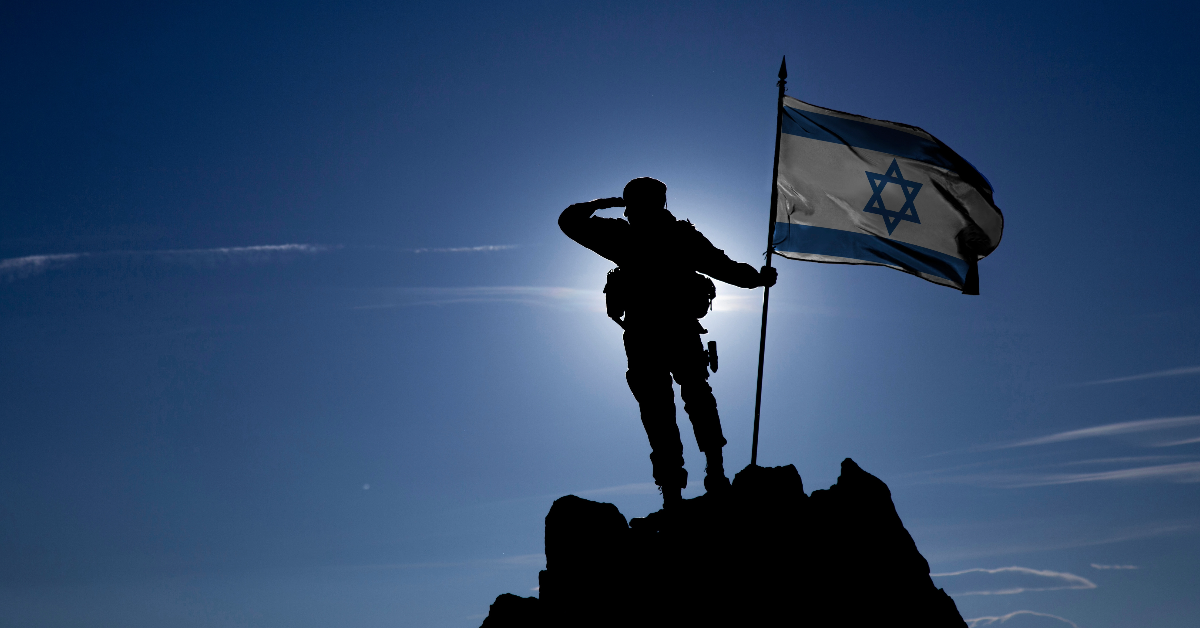 Soldier with an Israeli flag in silhouette.